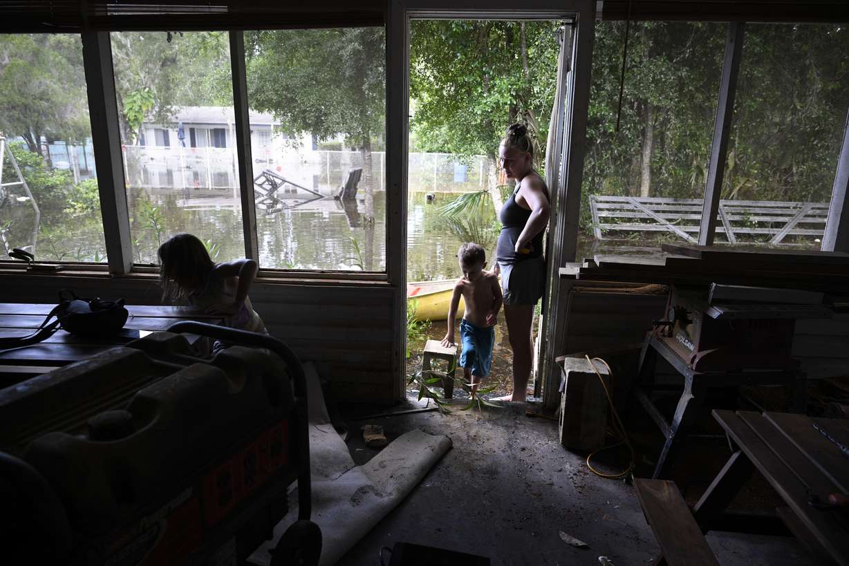 Hailey Morgan, right, surveys the damage to their flooded home after returning with her children, Aria Skye Hall, 7, left, and Kyle Ross, 7, in the aftermath of Hurricane Helene, Friday, in Crystal River, Fla. Morgan stayed with her grandmother and her children in Hernando, Fla., as the storm made landfall.