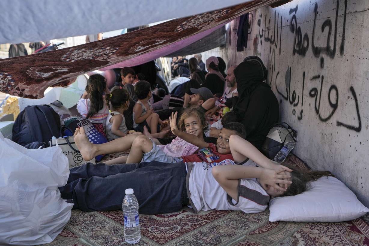 Children with their families lie on the ground in Beirut's Martyrs' square after fleeing the Israeli airstrikes in Beirut's southern suburbs, Saturday.