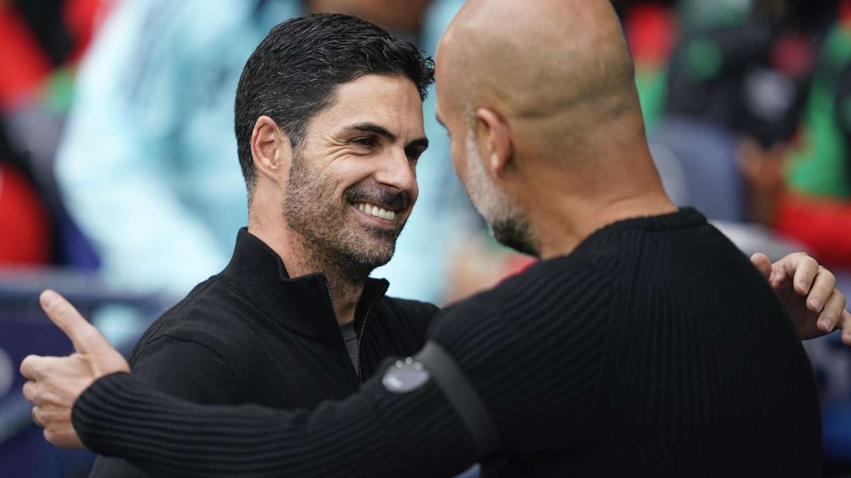 Arsenal's manager Mikel Arteta, left, embraces Manchester City's head coach Pep Guardiola before the English Premier League soccer match between Manchester City and Arsenal at the Etihad stadium in Manchester, England, Sunday, Sept. 22, 2024.