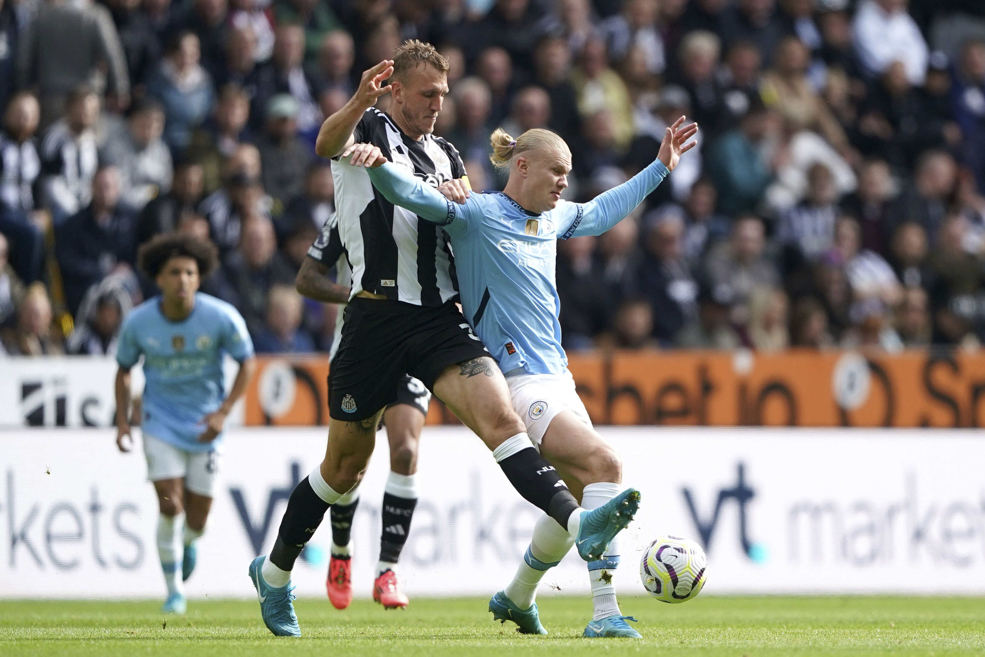 Newcastle United's Dan Burn, left, and Manchester City's Erling Haaland battle for the ball during the Premier League match between Newcastle and Manchester City, at St James' Park, Newcastle upon Tyne, England, Saturday Sept. 28, 2024. 