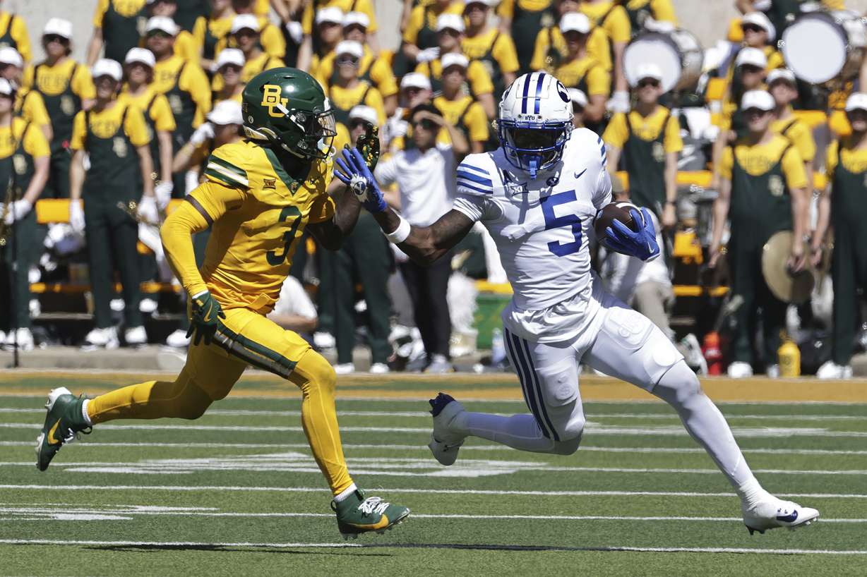 Brigham Young wide receiver Darius Lassiter (5) runs past Baylor safety Devyn Bobby in the first half of an NCAA college football game, Saturday, Sept. 28, 2024, in Waco, Texas.
