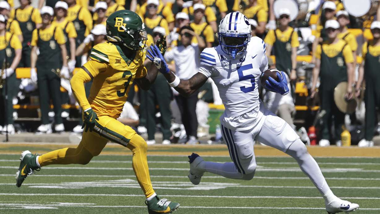 Brigham Young wide receiver Darius Lassiter (5) runs past Baylor safety Devyn Bobby in the first half of an NCAA college football game, Saturday, Sept. 28, 2024, in Waco, Texas.
