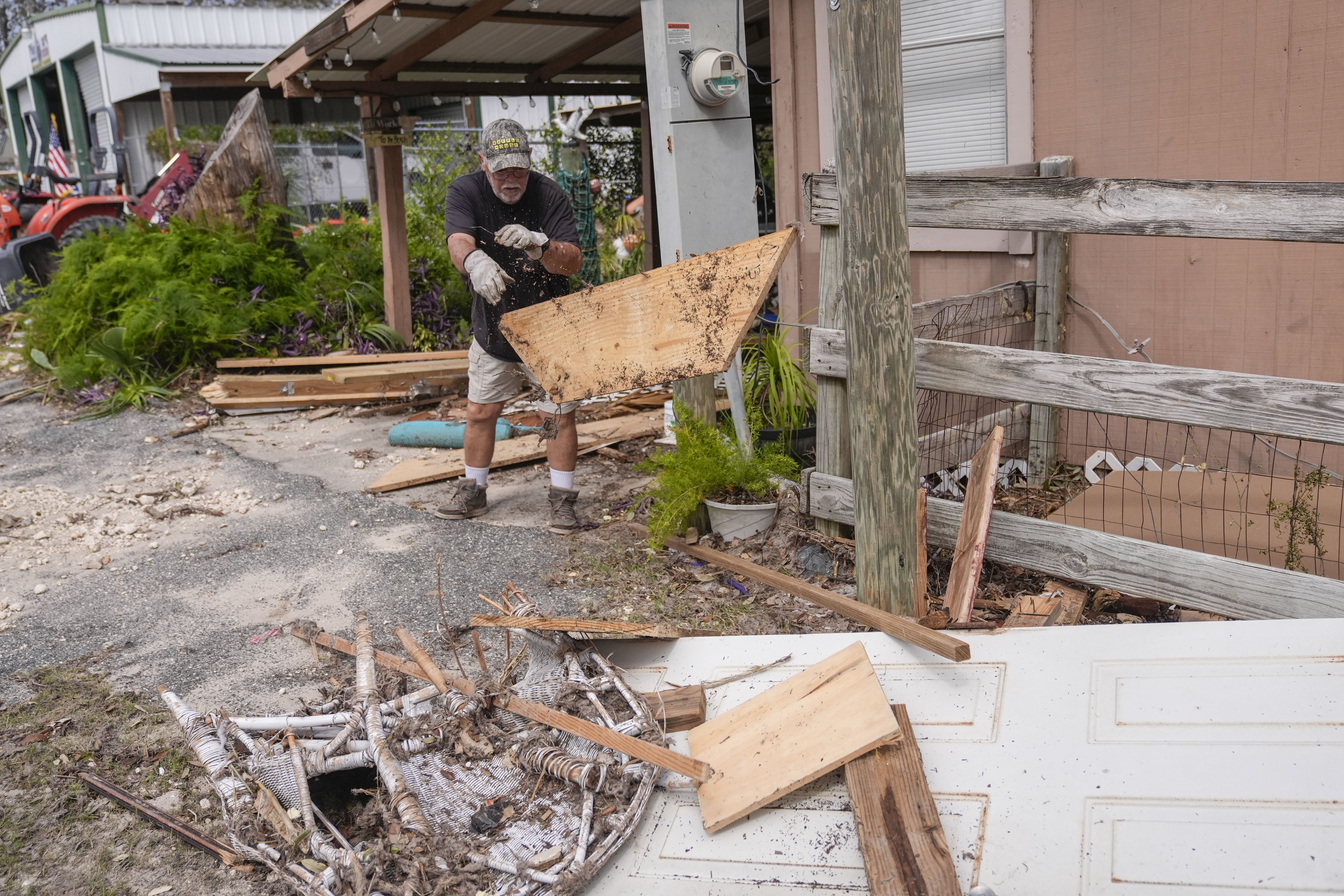 Dennis Johnson cleans out debris from his mother-in-law's heavily damaged home in the aftermath of Hurricane Helene, in Horseshoe Beach, Fla., Saturday, Sept. 28, 2024. 