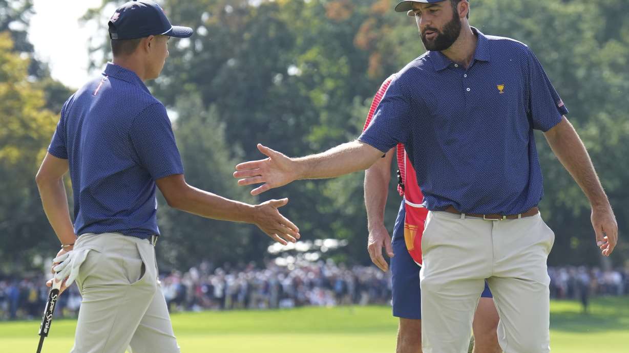 United States team member Scottie Scheffler, right, shakes hands with partner Collin Morikawa after making a putt on the 15th hole during the third round at the Presidents Cup golf tournament at Royal Montreal Golf Club in Montreal Saturday, Sept. 28, 2024.