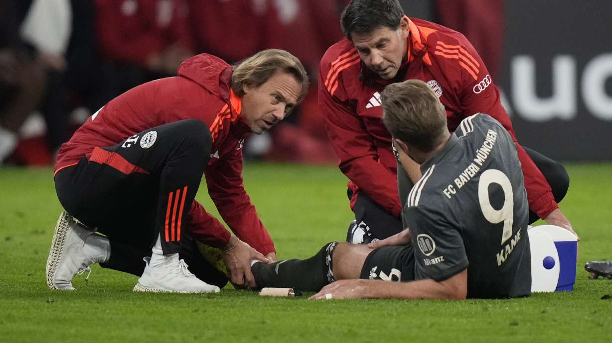 Bayern's Harry Kane is treated during the Bundesliga soccer match between Bayern Munich and Leverkusen at the Allianz Arena in Munich, Germany, Saturday, Sept. 28, 2024.