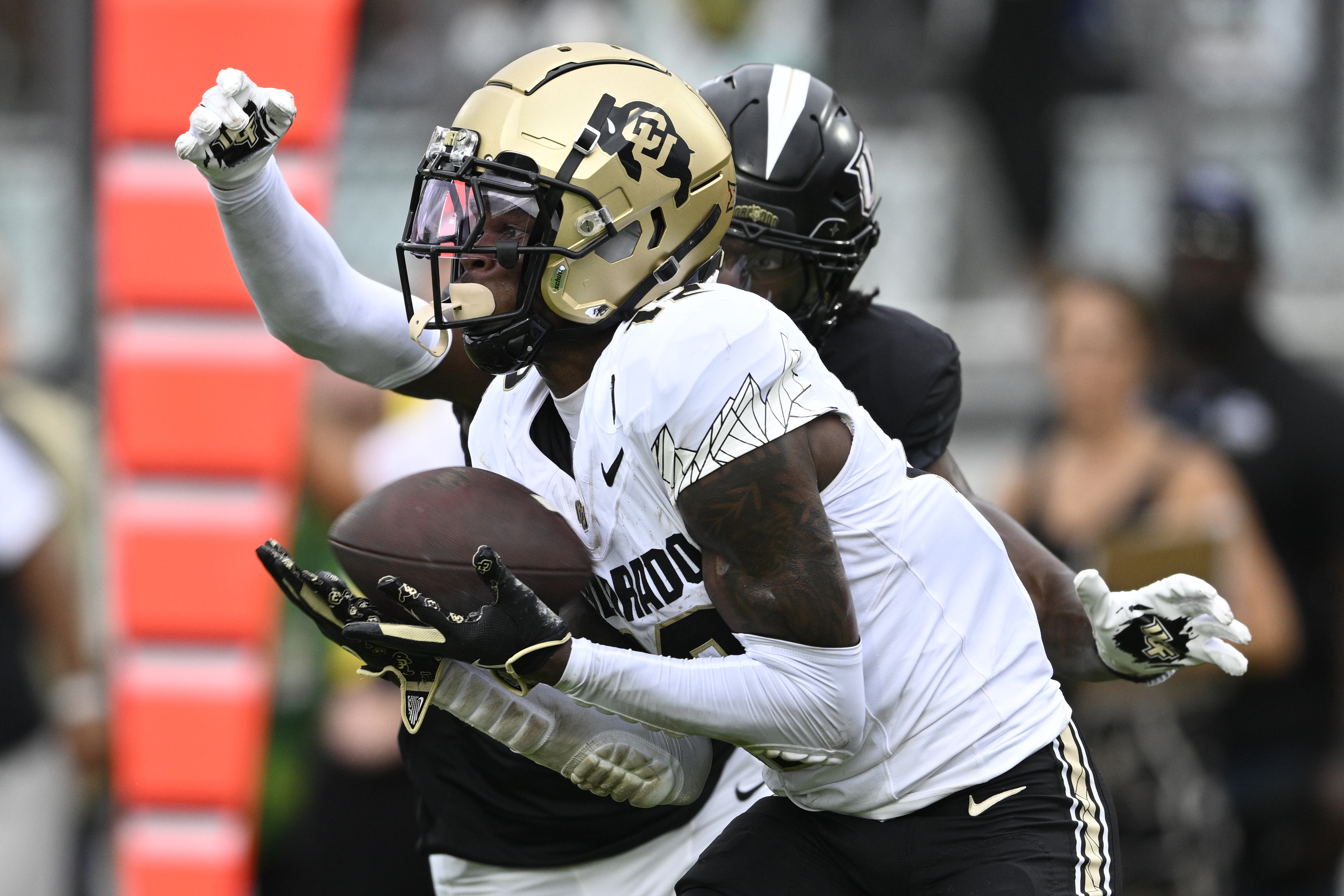 Colorado wide receiver Travis Hunter (12) catches a pass in the end zone for a 23-yard touchdown with Central Florida defensive back Brandon Adams behind him during the first half of an NCAA college football game, Saturday, Sept. 28, 2024, in Orlando, Fla.