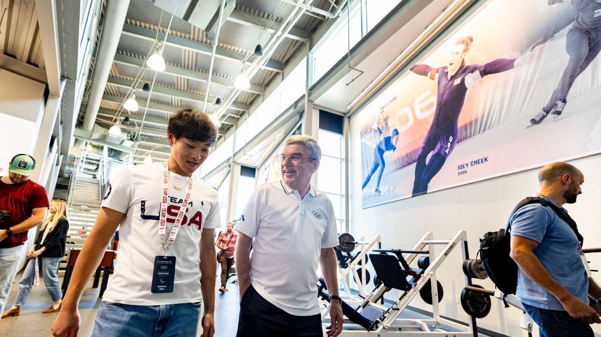 International Olympic Committee President Thomas Bach talks with Olympic speedskater Andrew Heo as they tour the U.S. Speedskating Speed Factory training center at the Utah Olympic Oval in Kearns on Saturday.