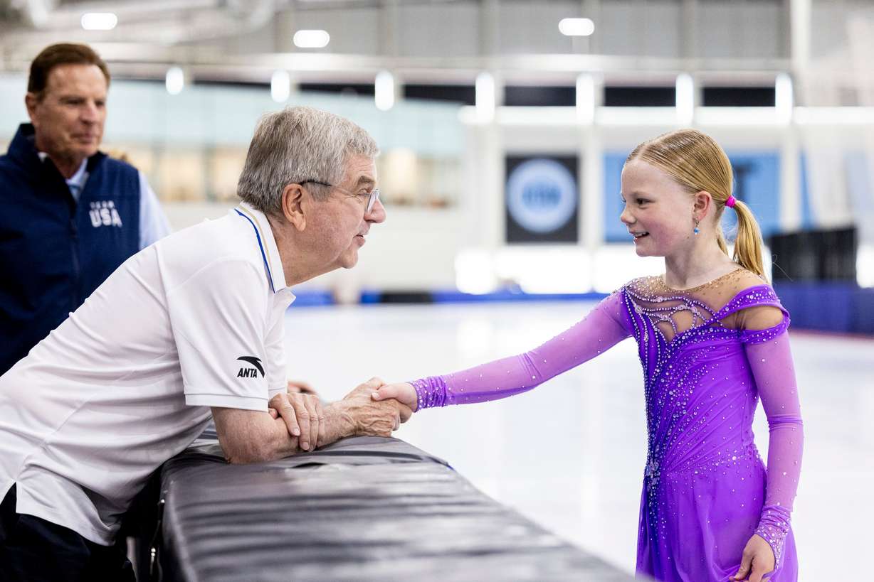 International Olympic Committee President Thomas Bach shakes hands with figure skater Annabelle Atkinson, 10, of Salt Lake City, as they talk at the Utah Olympic Oval in Kearns on Saturday.