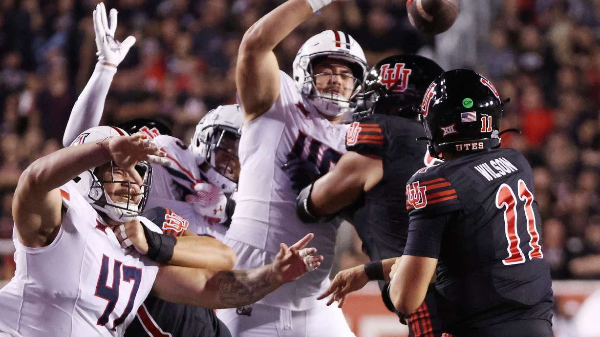 Utah Utes quarterback Isaac Wilson (11) throws under pressure from Arizona Wildcats defensive lineman Ta'ita'i Uiagalelei (46) in Salt Lake City on Saturday, Sept. 28, 2024.