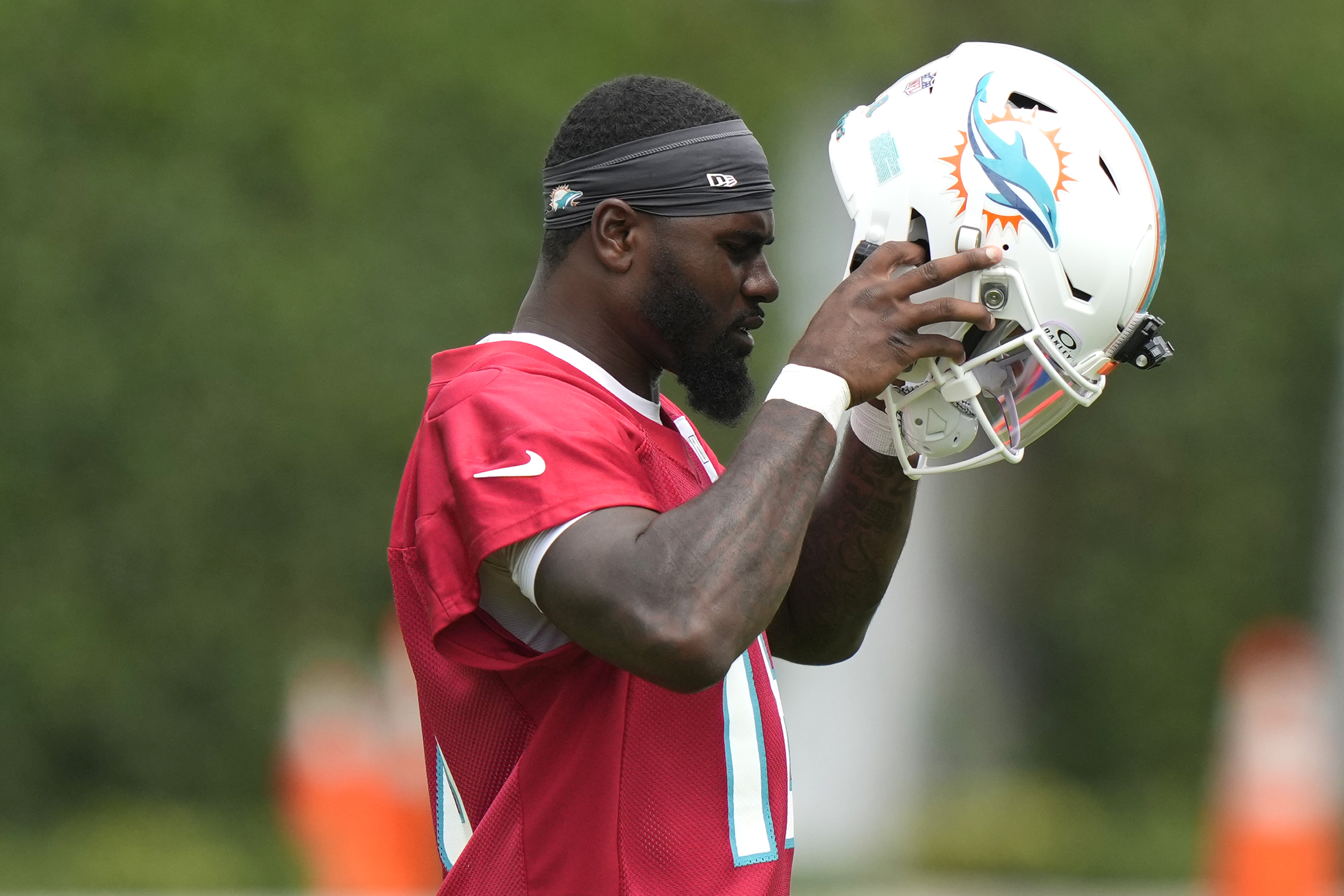 Miami Dolphins quarterback Tyler Huntley puts on his helmet during practice at the NFL football team's training facility, Wednesday, Sept. 18, 2024, in Miami Gardens, Fla. 