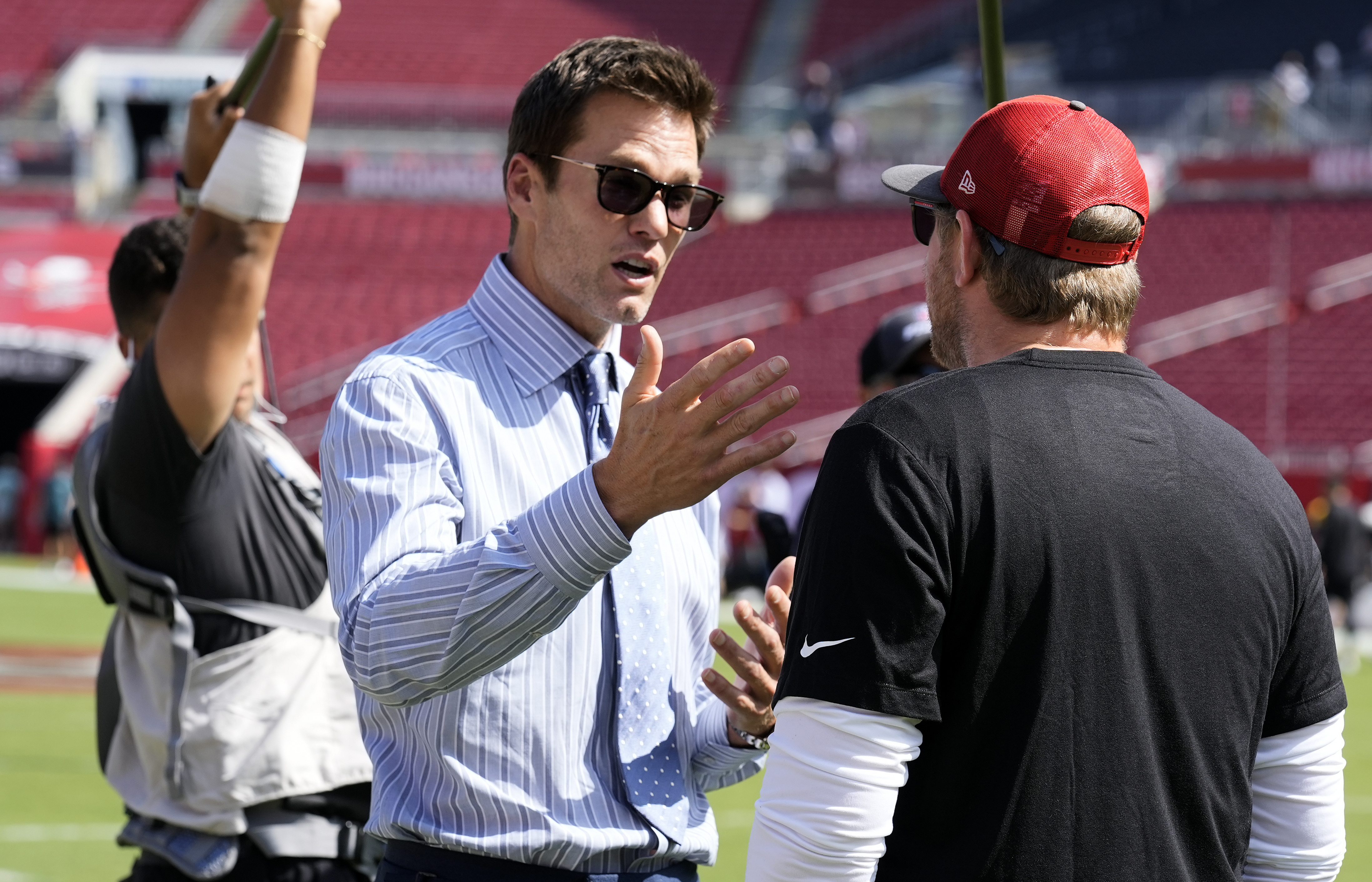 Former quarterback Tom Brady, left, talks to Tampa Bay Buccaneers offensive coordinator Liam Coen before an NFL football game between the Buccaneers and the Philadelphia Eagles Sunday, Sept. 29, 2024, in Tampa, Fla. 