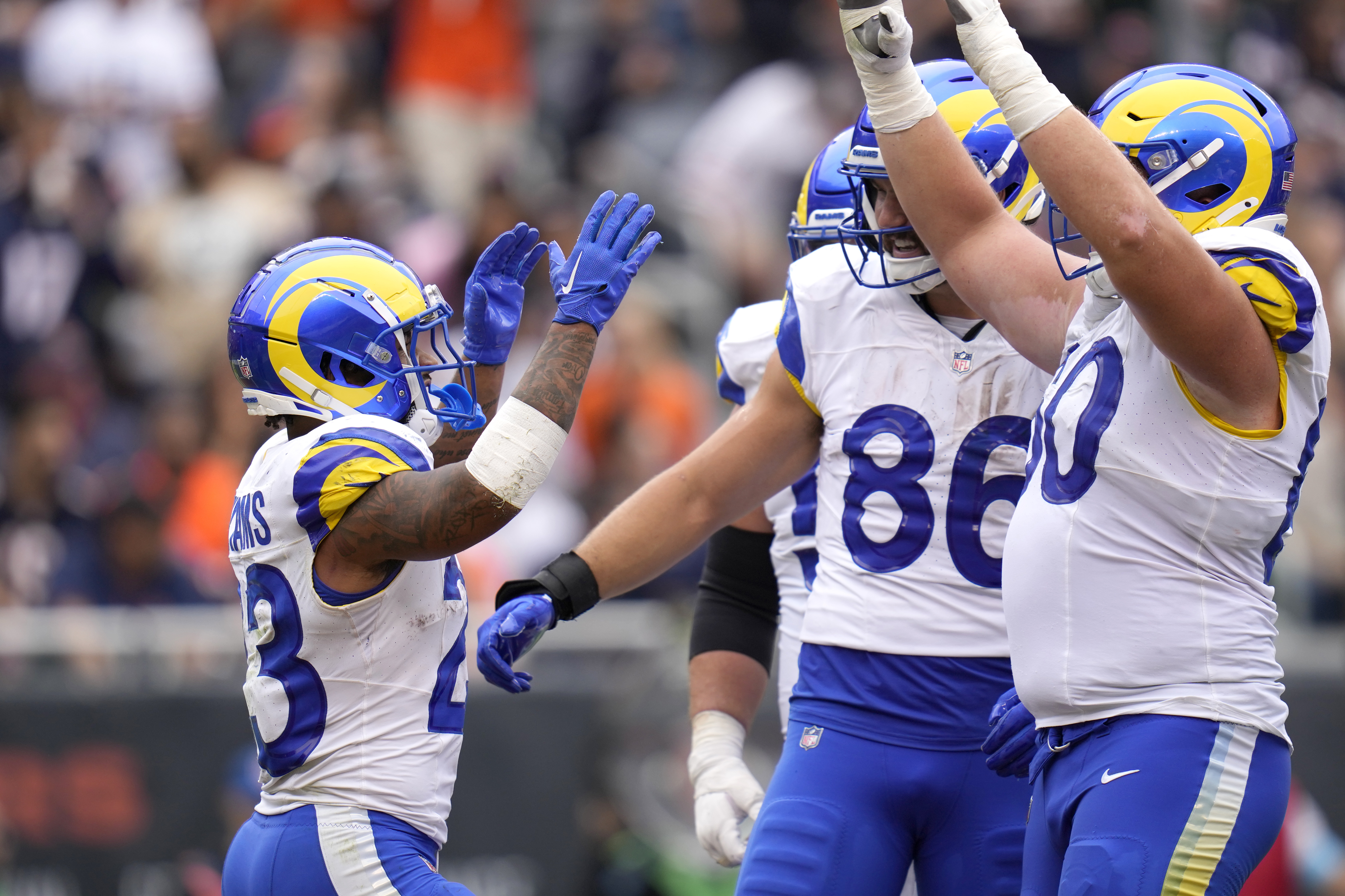 Los Angeles Rams running back Kyren Williams, left, celebrates with teammates Colby Parkinson (86) and Logan Bruss after his touchdown during the second half of an NFL football game against the Chicago Bears on Sunday, Sept. 29, 2024, in Chicago. 