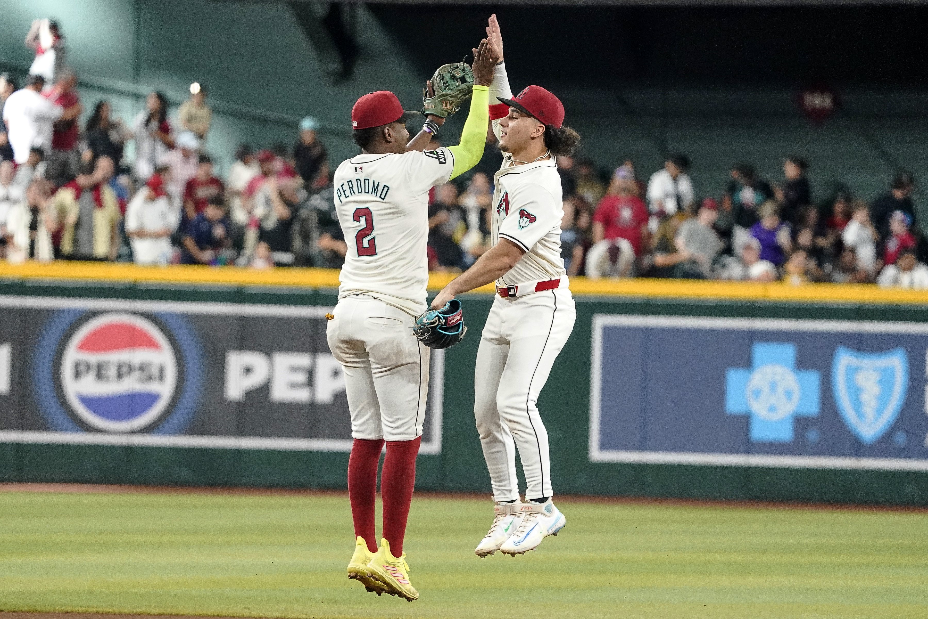 Arizona Diamondbacks' Geraldo Perdomo (2) and Alek Thomas, right, celebrate their win over the San Diego Padres at the end of the ninth inning of a baseball game, Sunday, Sept. 29, 2024, in Phoenix. 