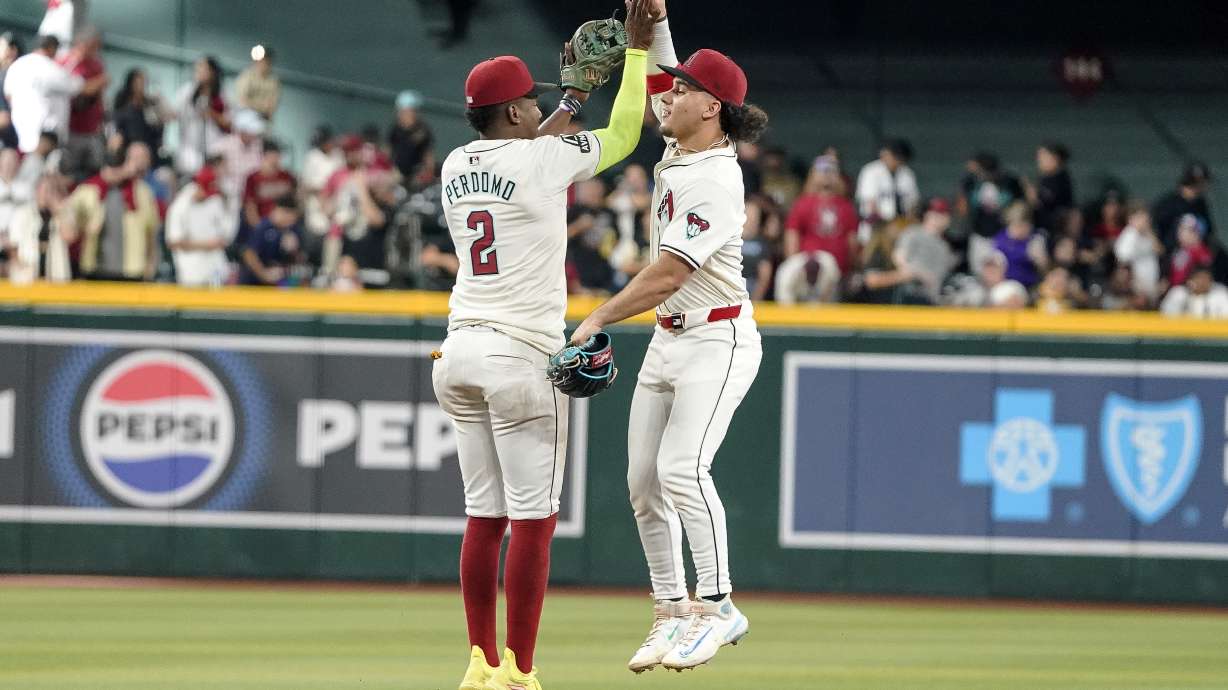 Arizona Diamondbacks' Geraldo Perdomo (2) and Alek Thomas, right, celebrate their win over the San Diego Padres at the end of the ninth inning of a baseball game, Sunday, Sept. 29, 2024, in Phoenix.