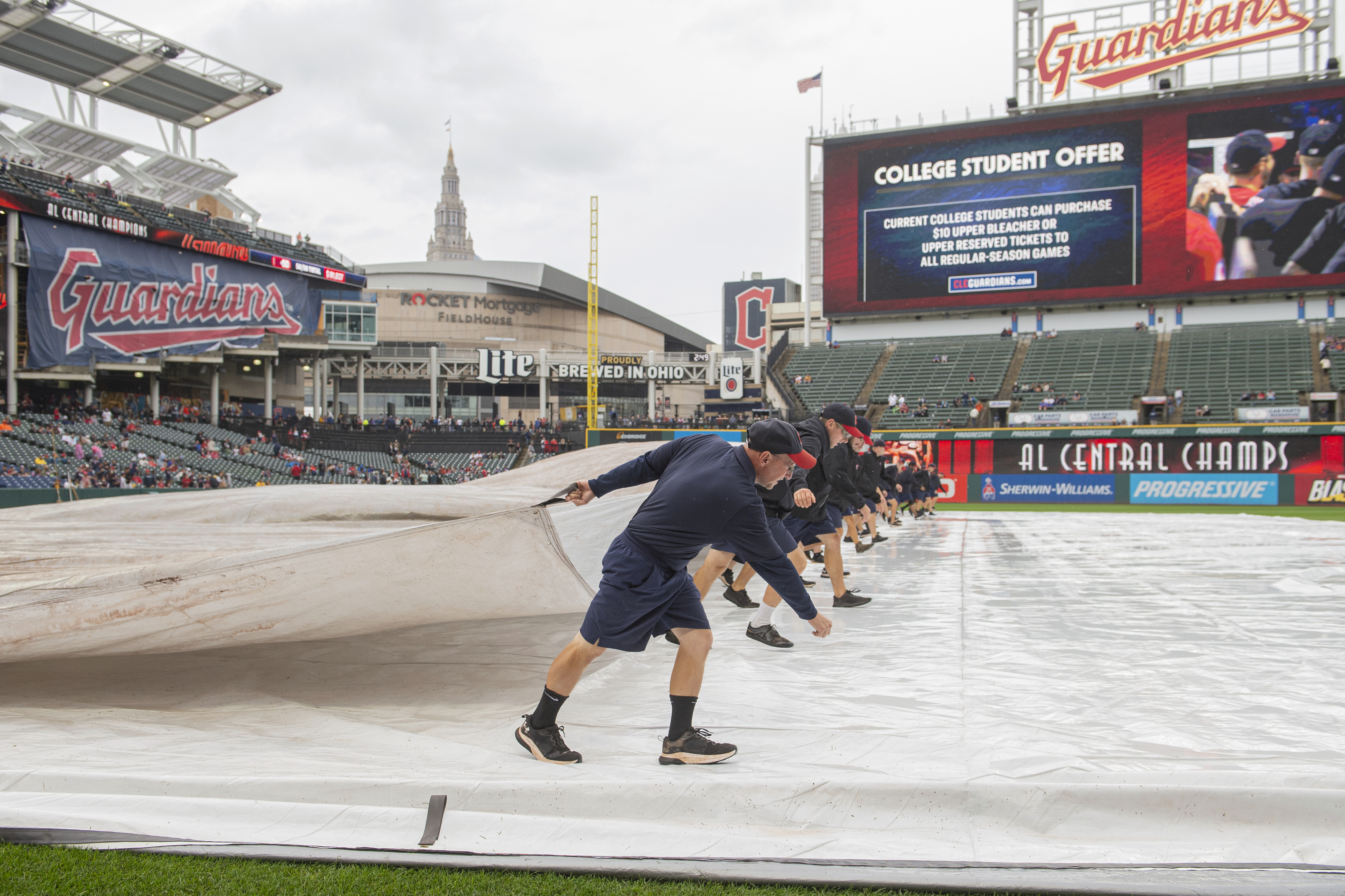 Cleveland Guardians grounds crew remove the tarp from the infield before a baseball game between the Guardians and the Houston Astros in Cleveland, Sunday, Sept. 29, 2024.
