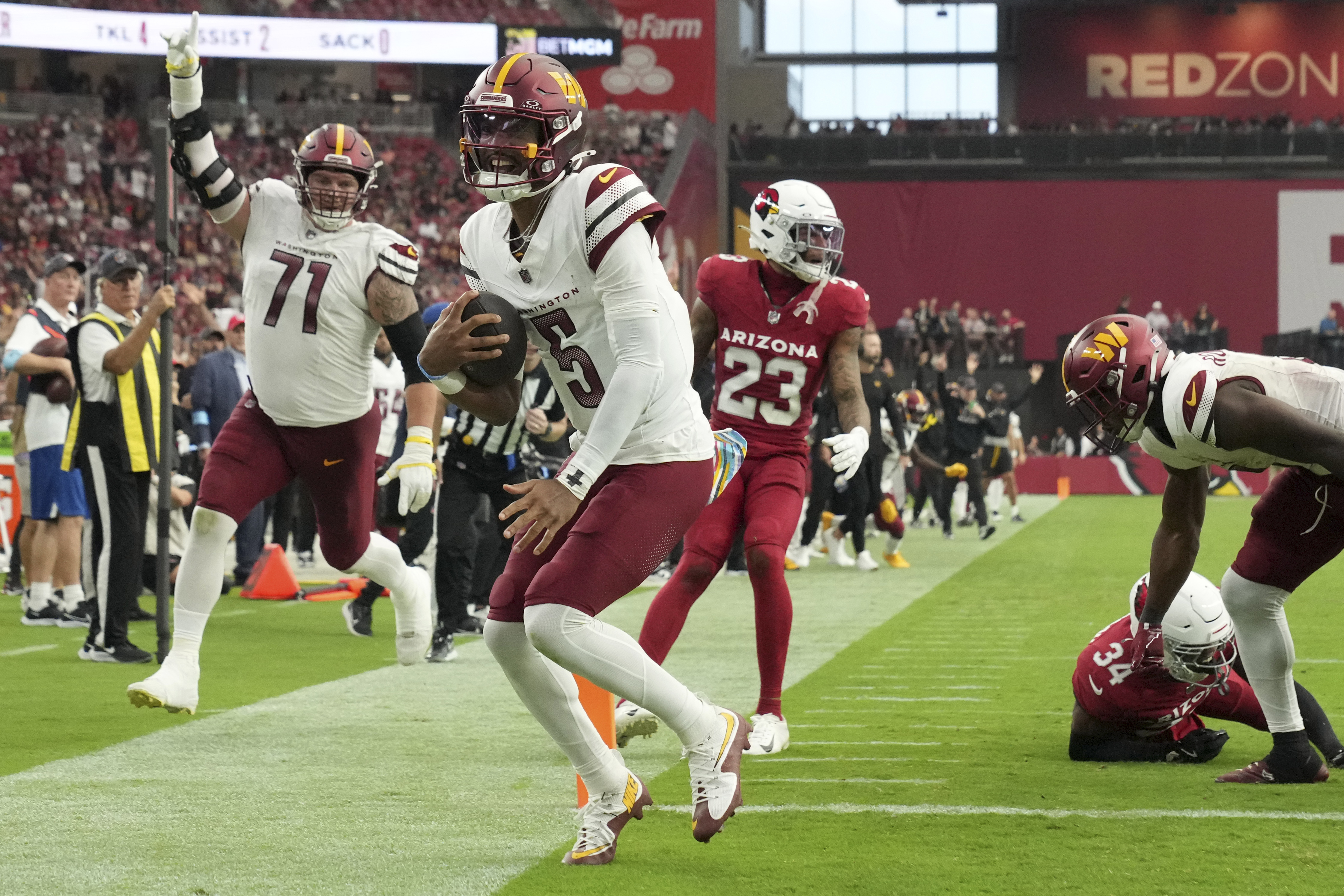 Washington Commanders quarterback Jayden Daniels (5) runs for a touchdown as Arizona Cardinals safety Jalen Thompson (34) defends during the second half of an NFL football game, Sunday, Sept. 29, 2024, in Glendale, Ariz.