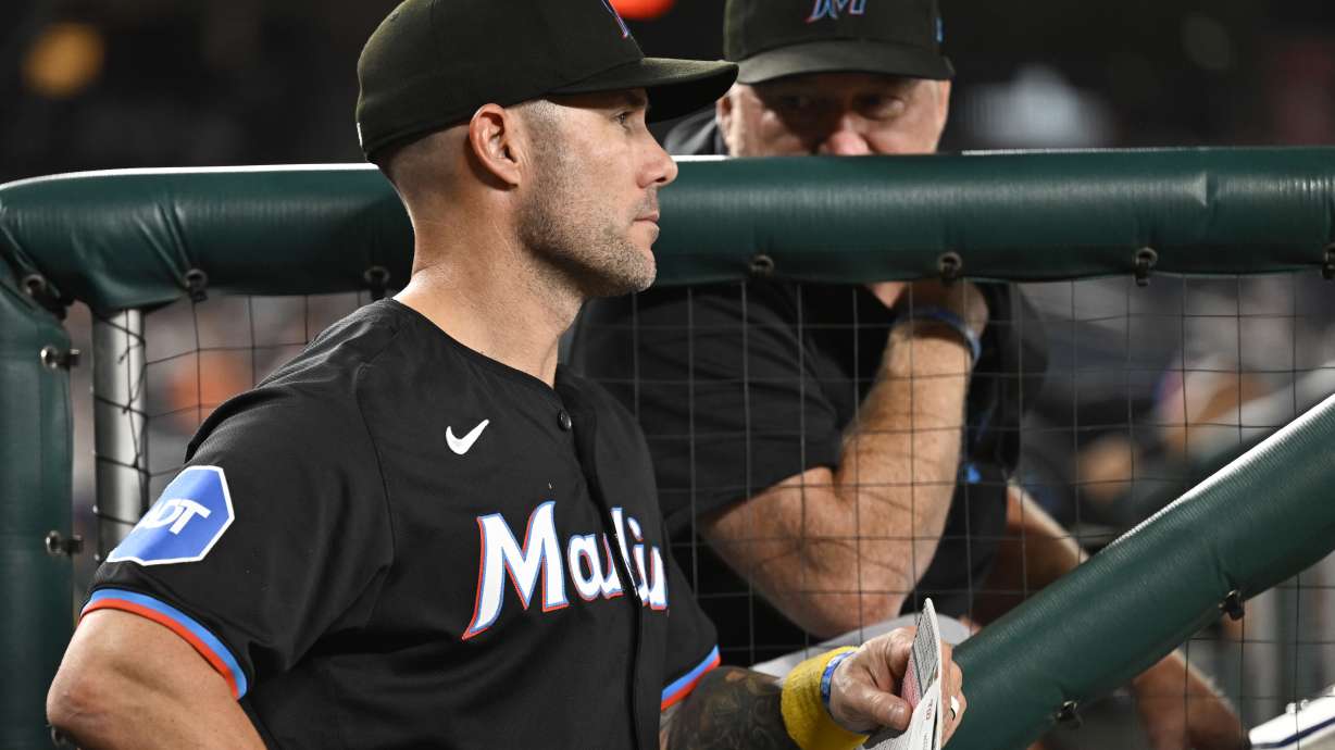 Miami Marlins manager Skip Schumaker, left, listens to Marlins pitching coach Mel Stottlemyre, right, in the dugout during the sixth inning of a baseball game against the Washington Nationals, Thursday, Sept. 12, 2024, in Washington.