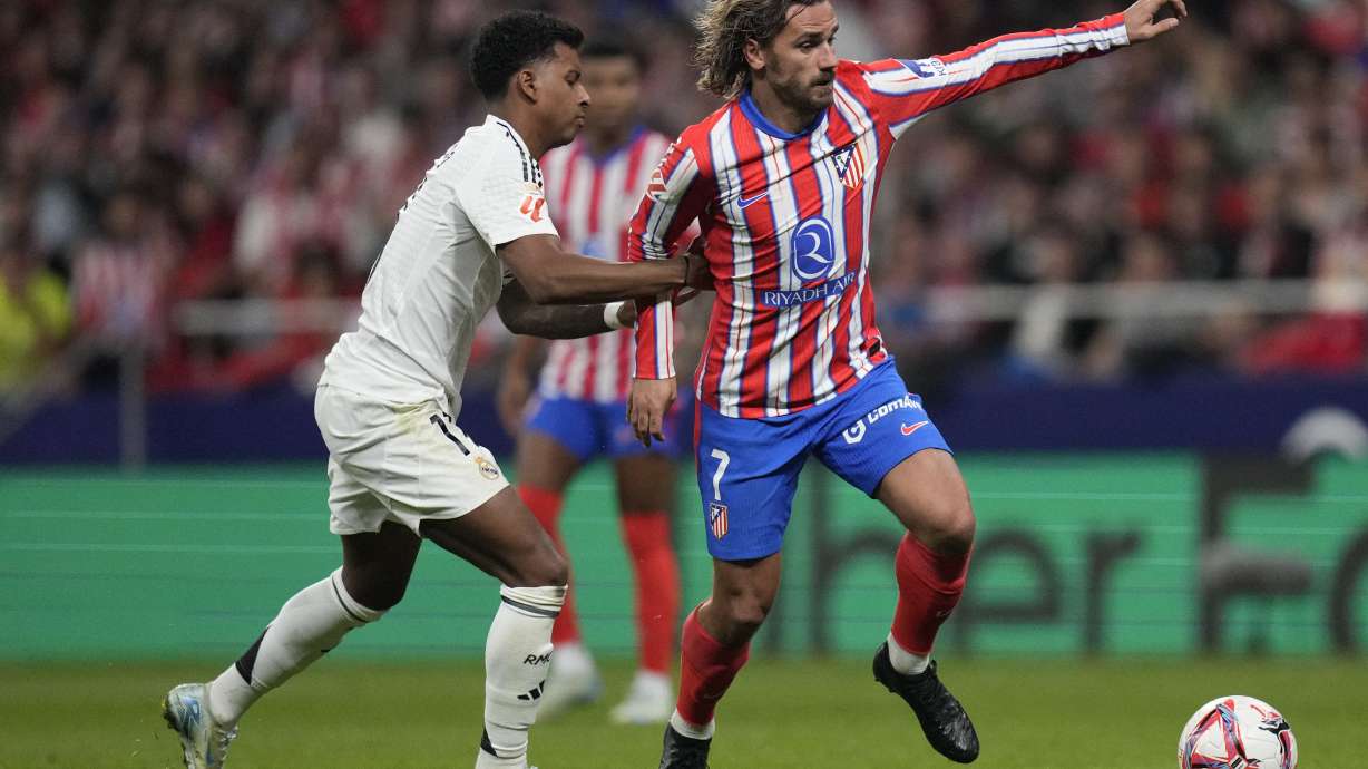Real Madrid's Rodrygo holds Atletico Madrid's Antoine Griezmann during the La Liga soccer match between Atletico Madrid and Real Madrid at the Metropolitano stadium in Madrid, Spain, Sunday, Sept. 29, 2024.