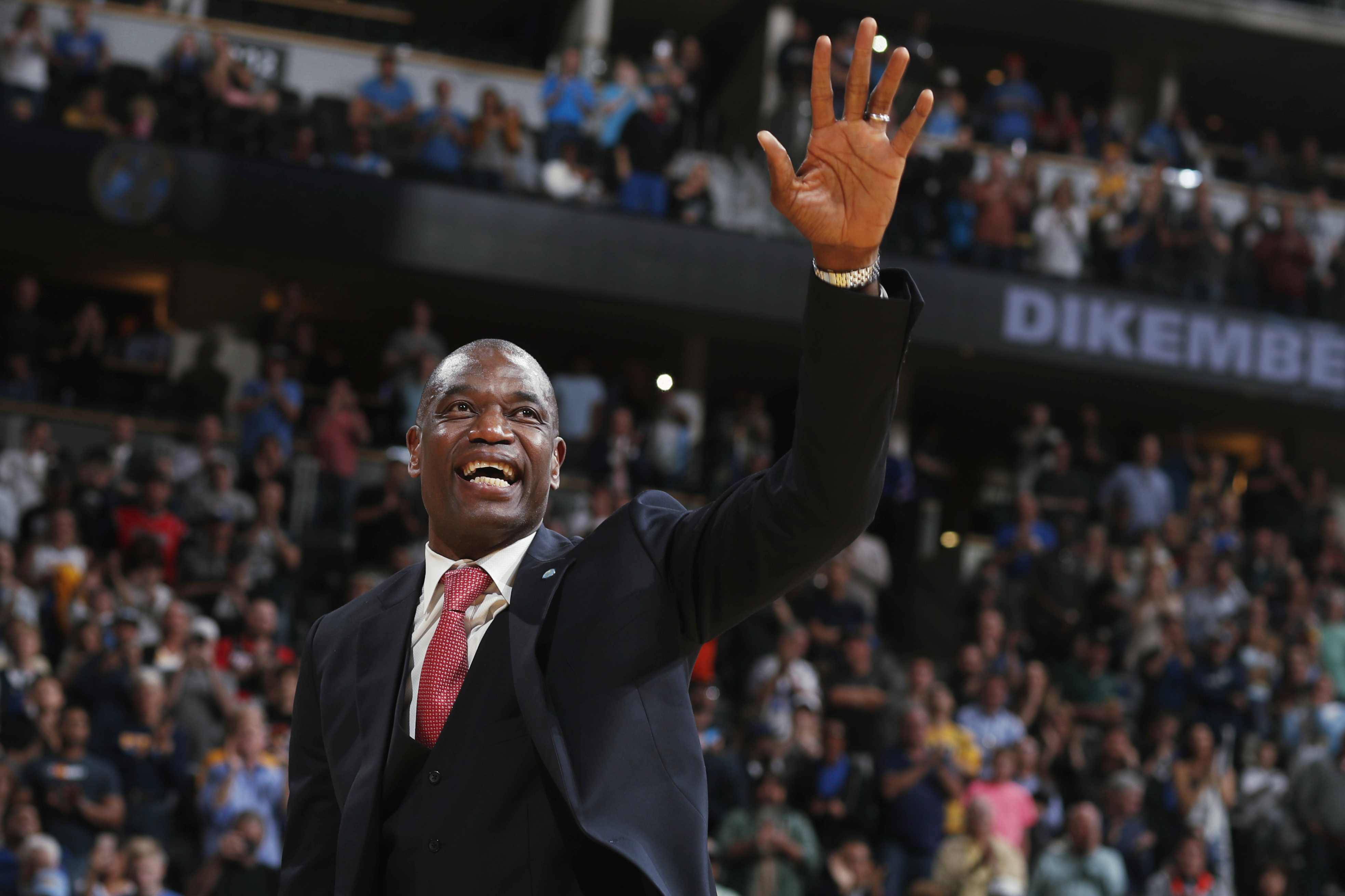 Retired Denver Nuggets center Dikembe Mutombo waves to the crowd as his jersey number was retired on Oct. 29, 2016, in Denver. Mutombo died Monday from brain cancer.