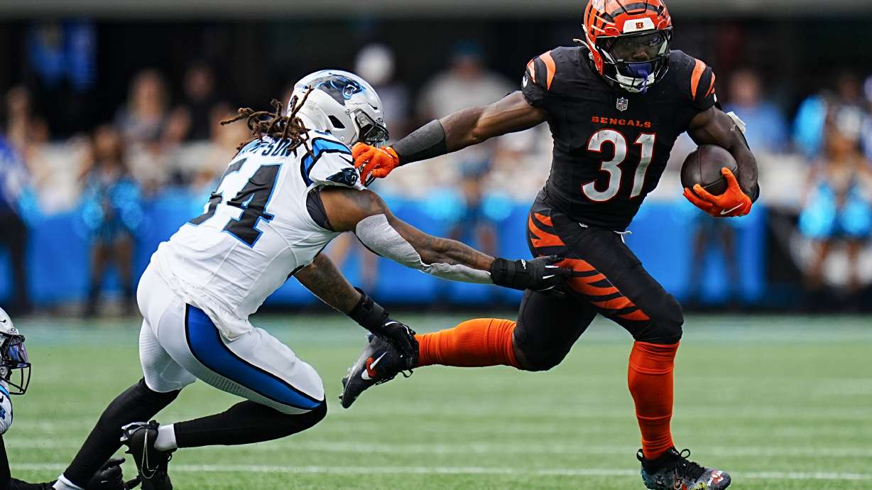 Cincinnati Bengals running back Zack Moss runs past Carolina Panthers linebacker Shaq Thompson during the second half of an NFL football game, Sunday, Sept. 29, 2024, in Charlotte, N.C.