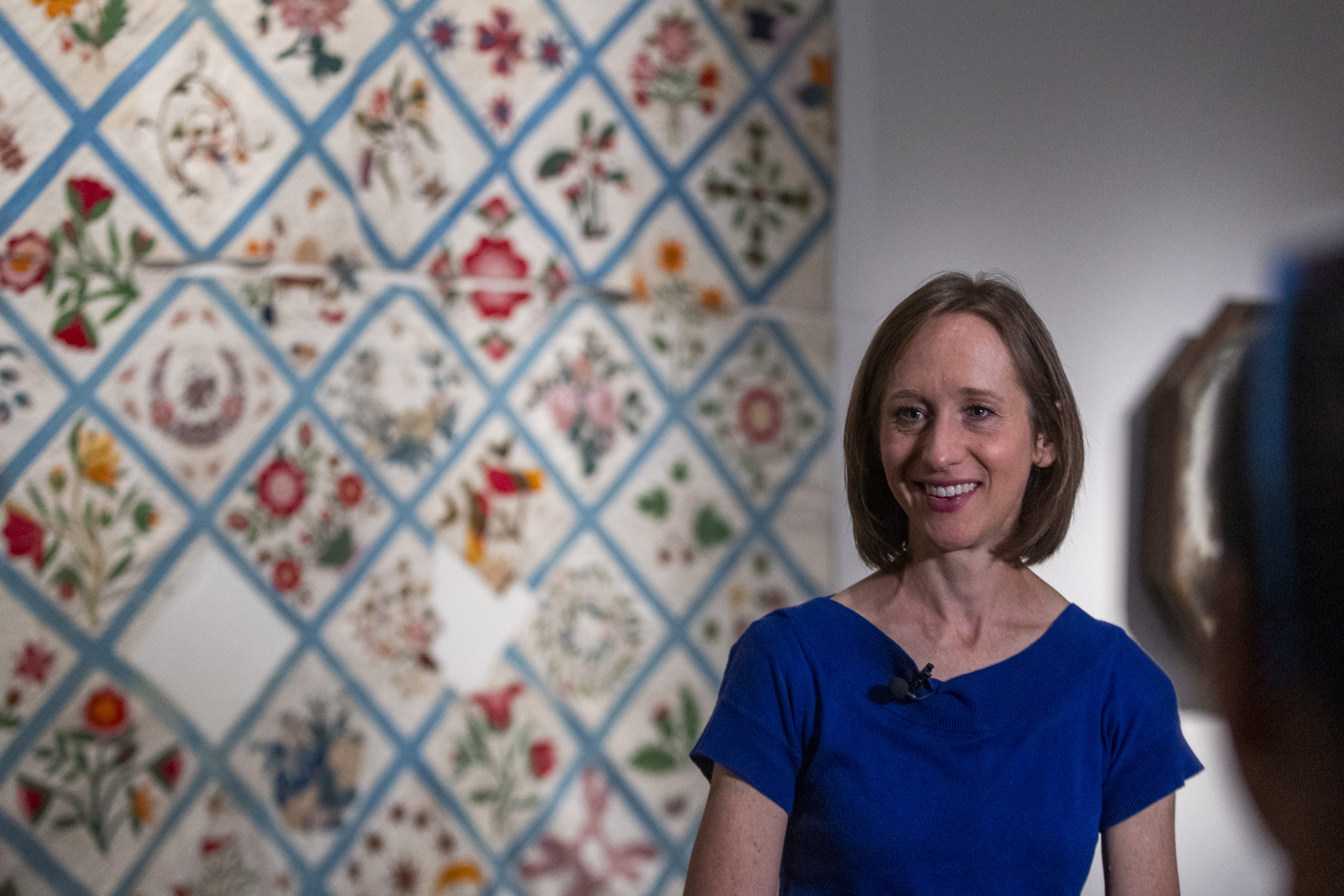 Curator Ashlee Whitaker Evans, from the Center for Latter-day Saint Arts, talks to media about the Fourteenth Ward Album Quilt piece behind her, at an exhibition organized by the Church History Museum and the Center for Latter-day Saint Arts featuring art created by, for, and about Latter-day Saints between 1830 and the present, in Salt Lake City on Monday.