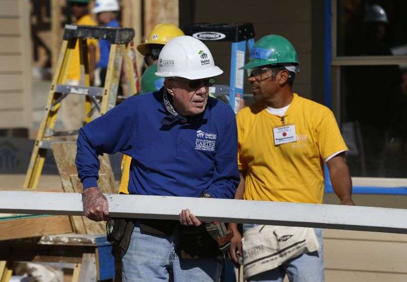Former President Jimmy Carter helps cut wood for home construction at a Habitat for Humanity construction site in the Globeville neighborhood of Denver, Colo., Oct. 9, 2013.