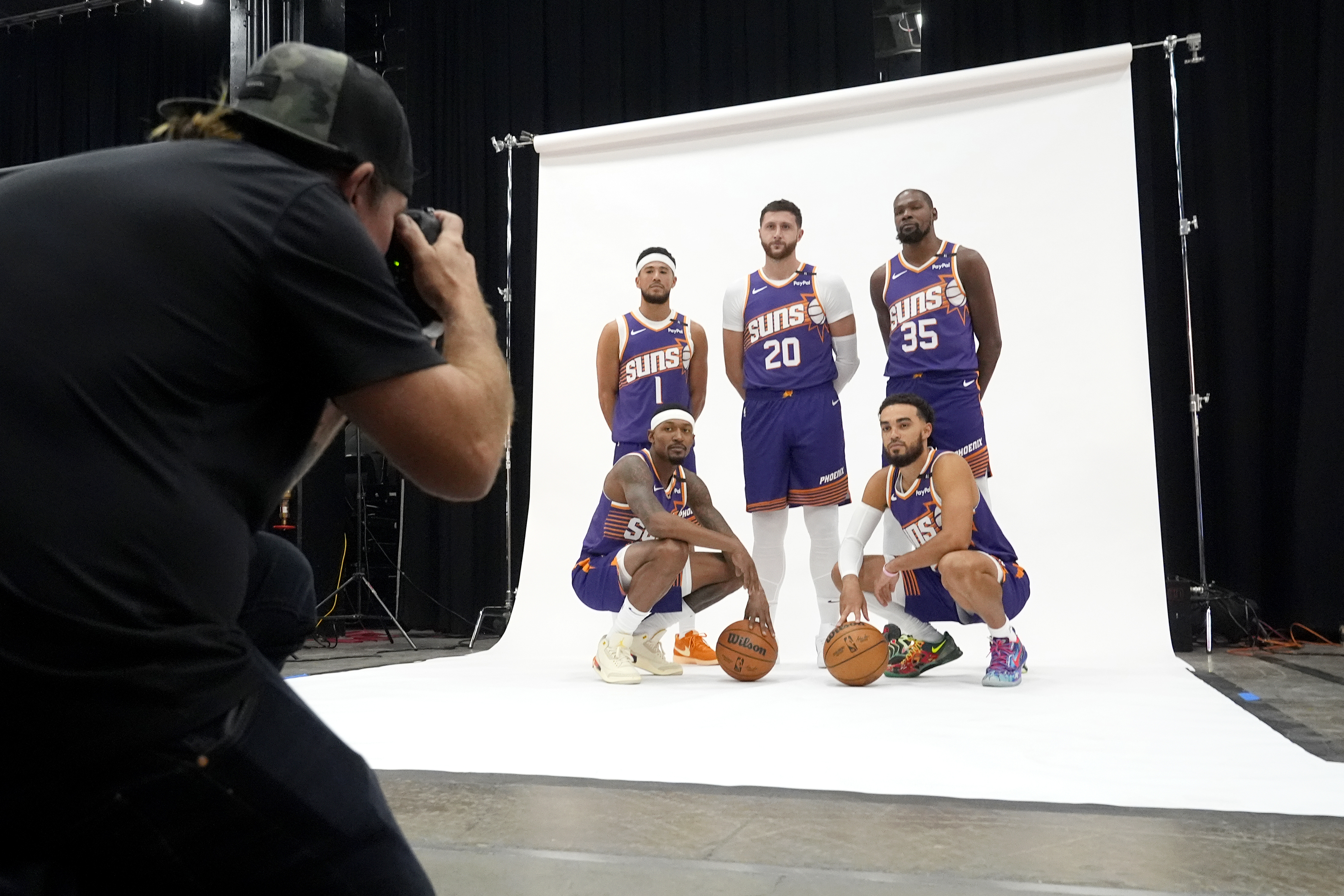 Phoenix Suns' Phoenix Suns guard Devin Booker (1), center Jusuf Nurkic (20), forward Kevin Durant (35), guard Bradley Beal, bottomleft, and guard Tyus Jones, bottom right, pose for a photo for team photographer Barry Gossage during an NBA basketball media day Monday, Sept. 30, 2024, in Phoenix. 
