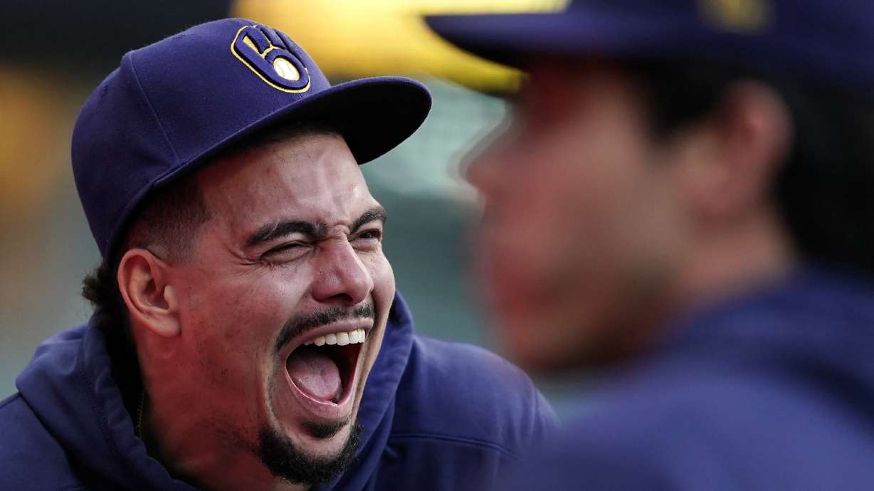 Milwaukee Brewers' Willy Adames, left, laughs from the dugout during the eighth inning of a baseball game against the New York Mets, Sunday, Sept. 29, 2024, in Milwaukee.