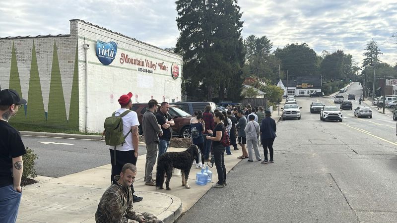 People wait to gather water at Mountain Valley Water in the aftermath of Hurricane Helene in West Asheville, N.C., Monday.