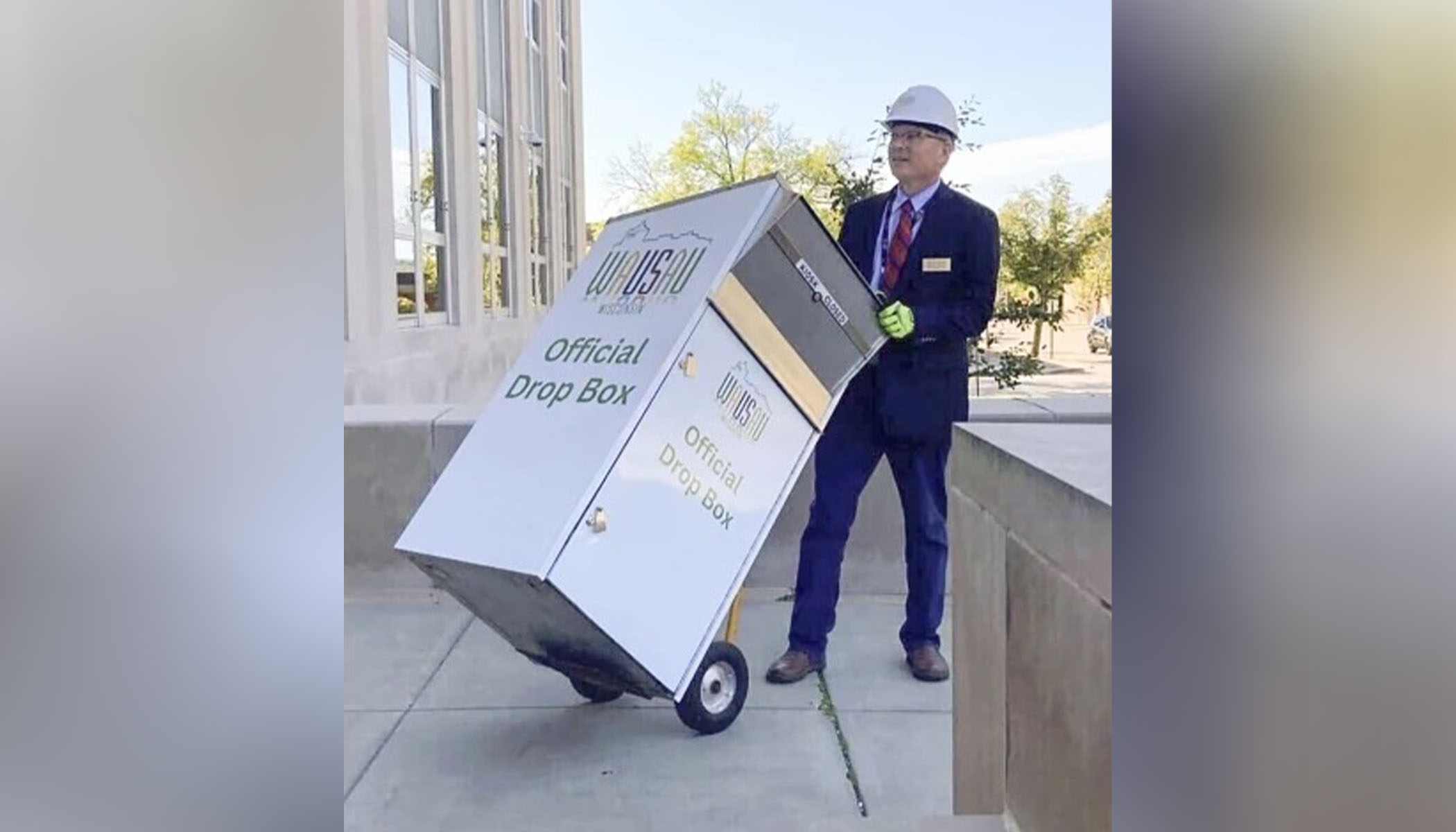 Wausau Mayor Doug Diny uses a dolly to remove the city's lone drop box from in front of the city hall in Wausau, Wis., on Sept. 22.  