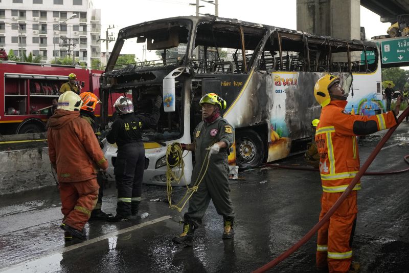 Rescuers work at the site of a bus that caught fire, carrying young students with their teachers, in suburban Bangkok, Thailand, Tuesday.