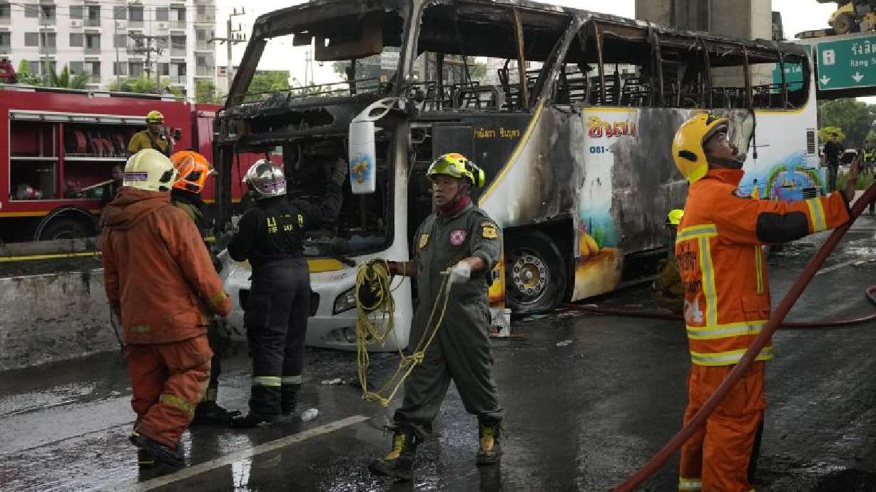 Rescuers work at the site of a bus that caught fire, carrying young students with their teachers, in suburban Bangkok, Thailand, Tuesday.