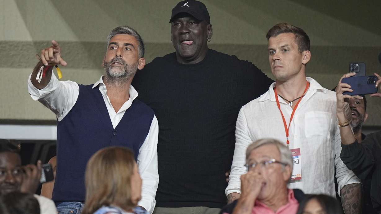 American former professional basketball player Michael Jordan, center, gestures as he attends the Champions League opening phase soccer match between Monaco and Barcelona at the Louis II stadium, in Monaco, Monaco, Thursday, Sept. 19, 2024.