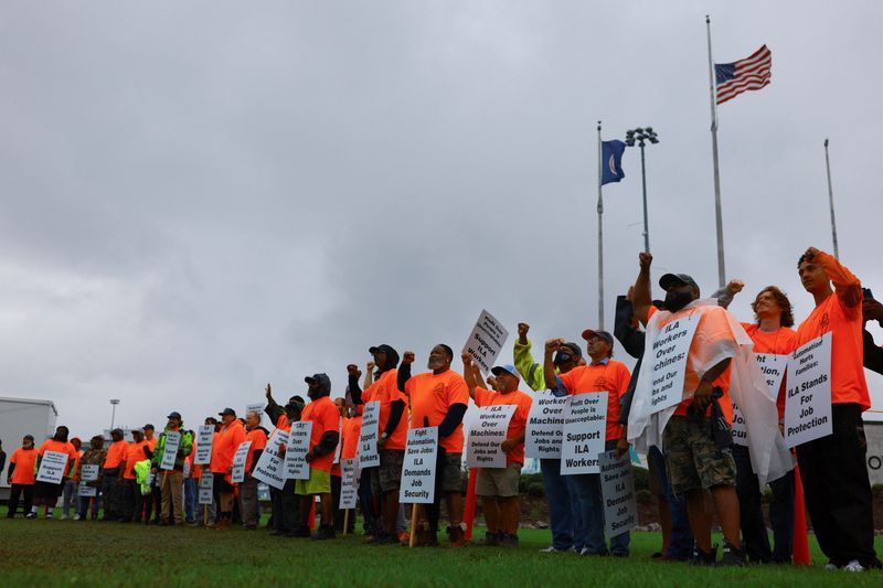 Port workers from the International Longshoremen's Association participate in a strike in the Virginia International Gateway in Portsmouth, Va., Tuesday.