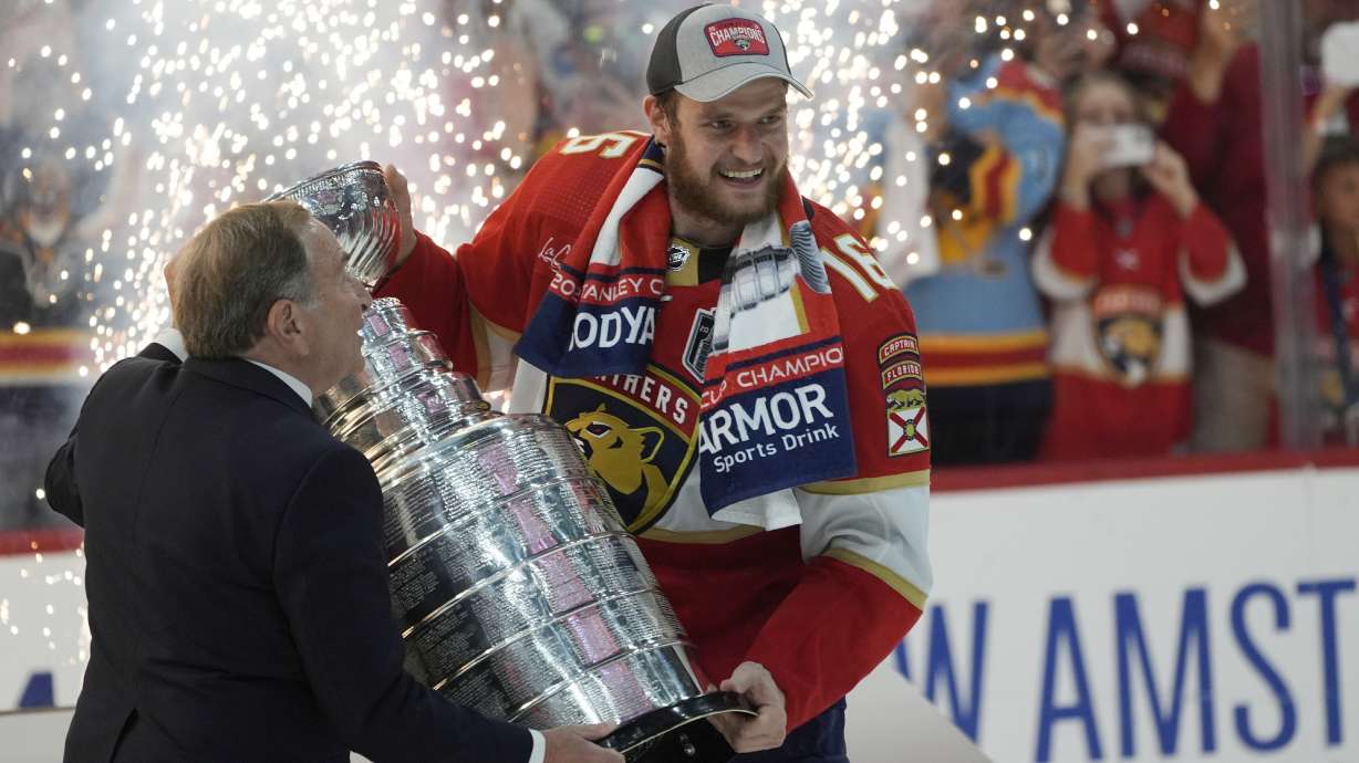 FILE - NHL commissioner Gary Bettman, left, presents the Stanley Cup to Florida Panthers center Aleksander Barkov after the Panthers beat the Edmonton Oilers in Game 7 of the NHL hockey Stanley Cup Finals, Monday, June 24, 2024, in Sunrise, Fla.