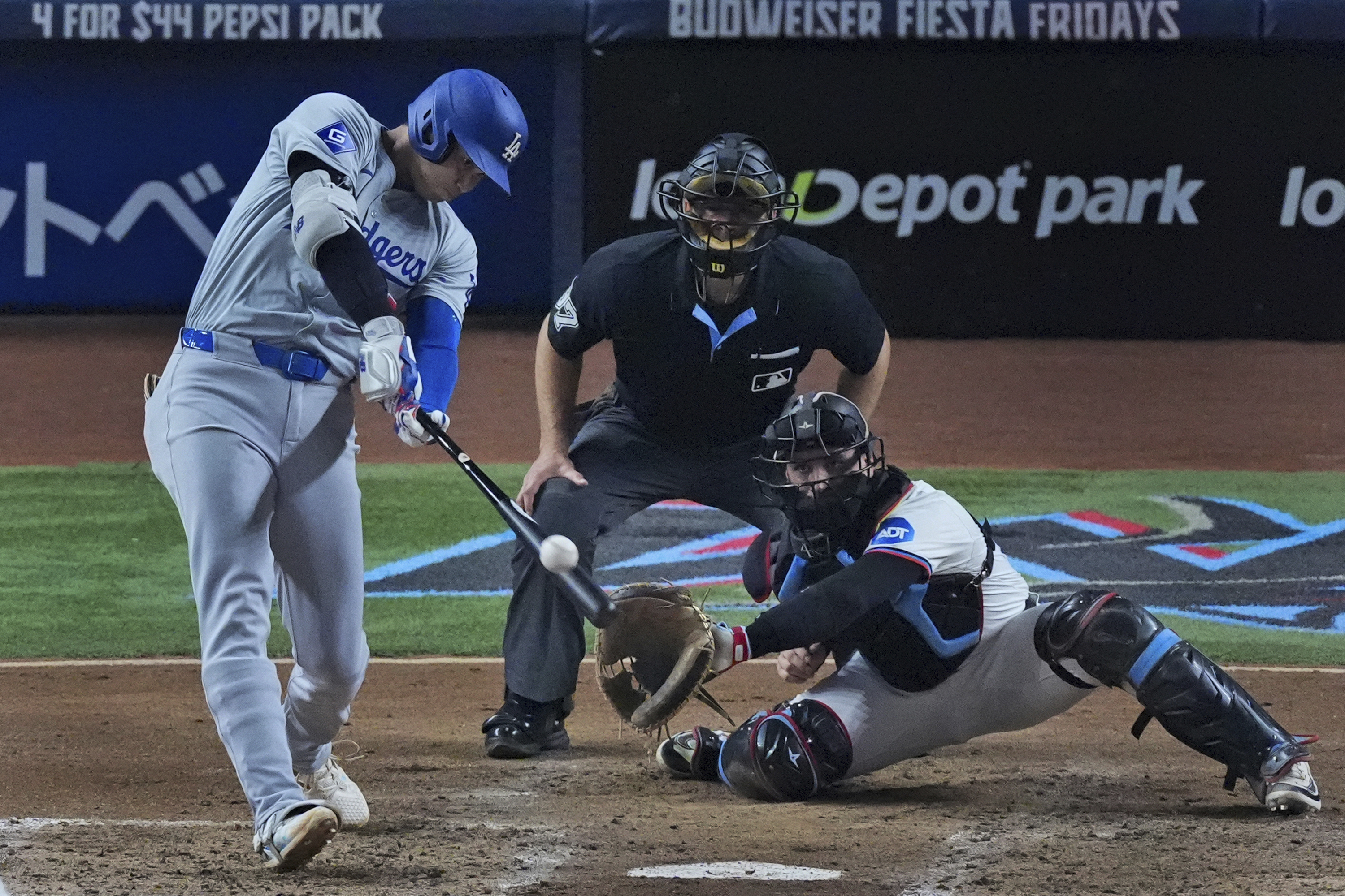 Los Angeles Dodgers' Shohei Ohtani, of Japan, hits a home run scoring Hunter Feduccia during the third inning of a baseball game against the Miami Marlins, Tuesday, Sept. 17, 2024, in Miami.