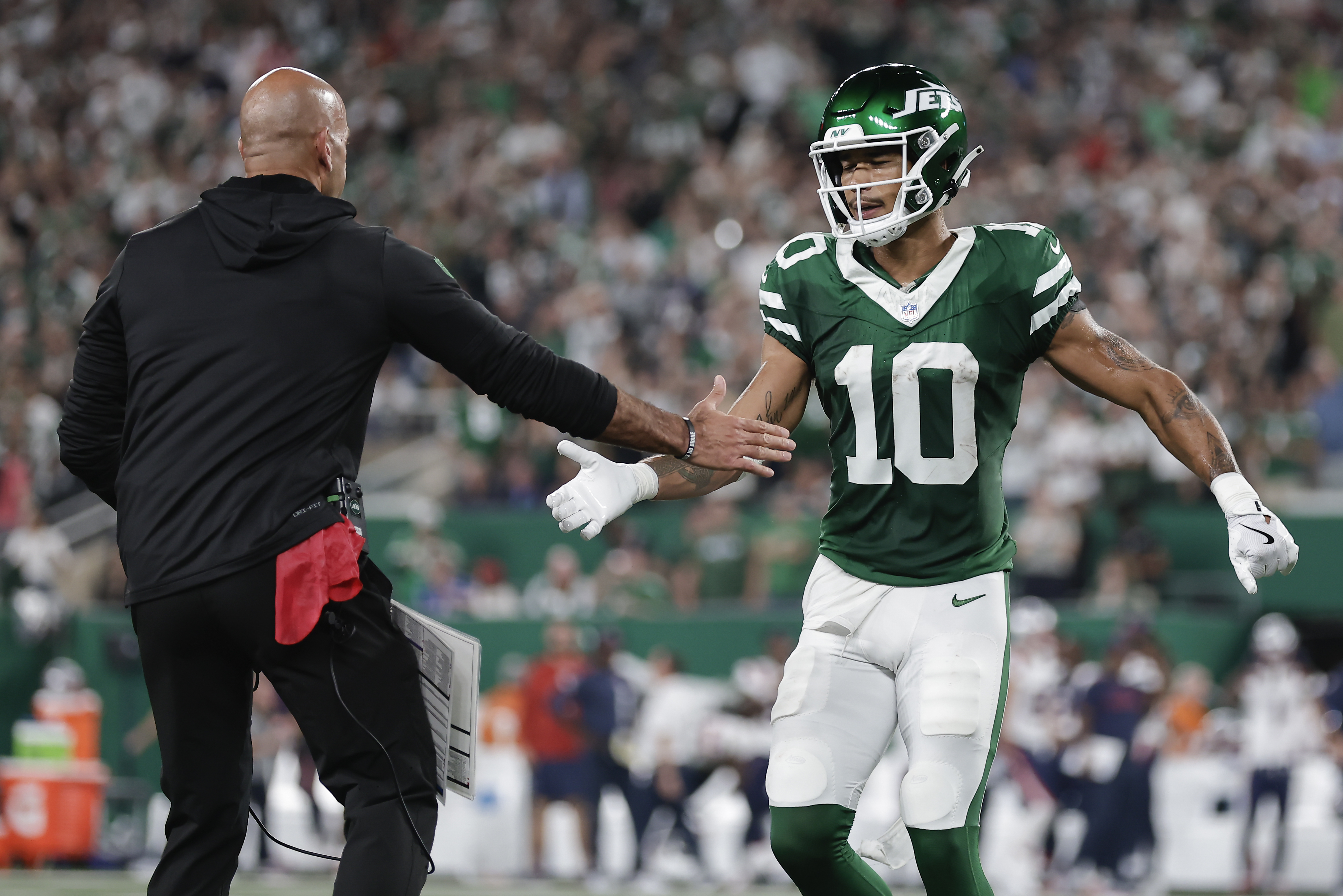 New York Jets wide receiver Allen Lazard (10) is congratulated by New York Jets head coach Robert Saleh after Lazard scored a touchdown against the New England Patriots during the first quarter of an NFL football game, Thursday, Sept. 19, 2024, in East Rutherford, N.J.