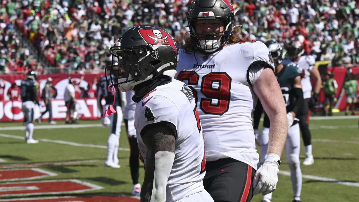Tampa Bay Buccaneers' Bucky Irving, left, and Cody Mauch react after Irving's touchdown during the second half of an NFL football game, Sunday, Sept. 29, 2024, in Tampa, Fla.