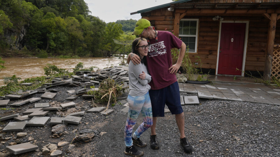 Jonah Wark and Sara Martin outside their damaged home on the Pigeon River in the aftermath of Hurricane Helene, Saturday, in Newport, Tenn. Some missionaries for The Church of Jesus Christ of Latter-day Saints are helping with hurricane cleanup efforts. 