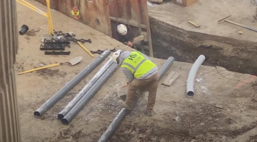 A construction worker uses a rotary saw at a worksite.