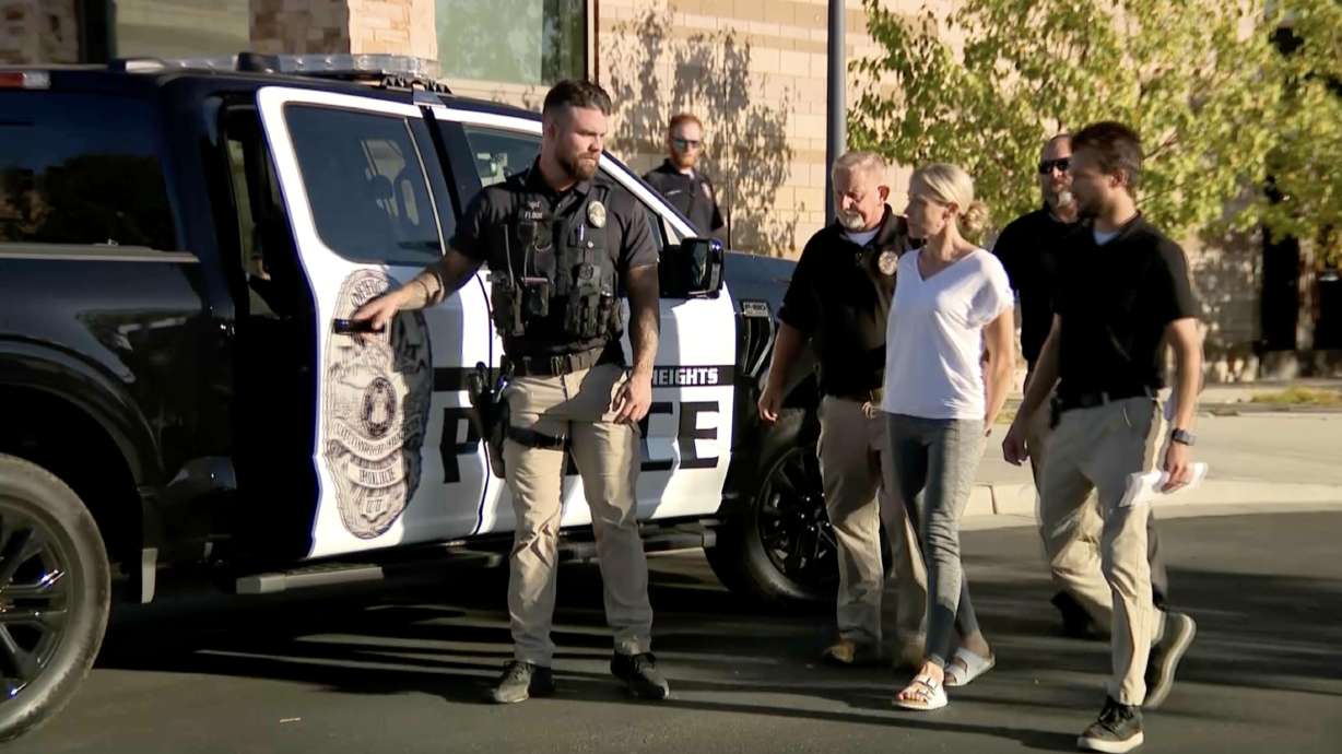 Cottonwood Heights police officers escort Jennifer Gledhill into a police car on Oct. 2, 2024. She will face trial in December on charges of shooting and killing her husband.