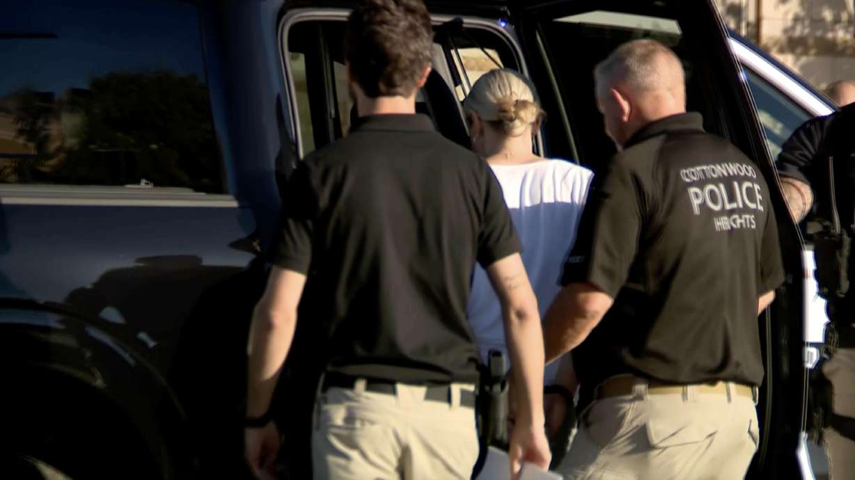 Cottonwood Heights police officers escort Jennifer Gledhill into a police car on Oct. 2, 2024. She was arrested for investigation of the murder of her husband, Matthew Johnson.