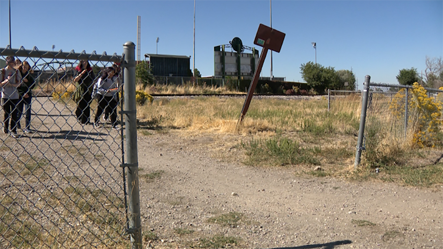 Students cross train tracks toward a neighborhood east of Kearns High on Wednesday.