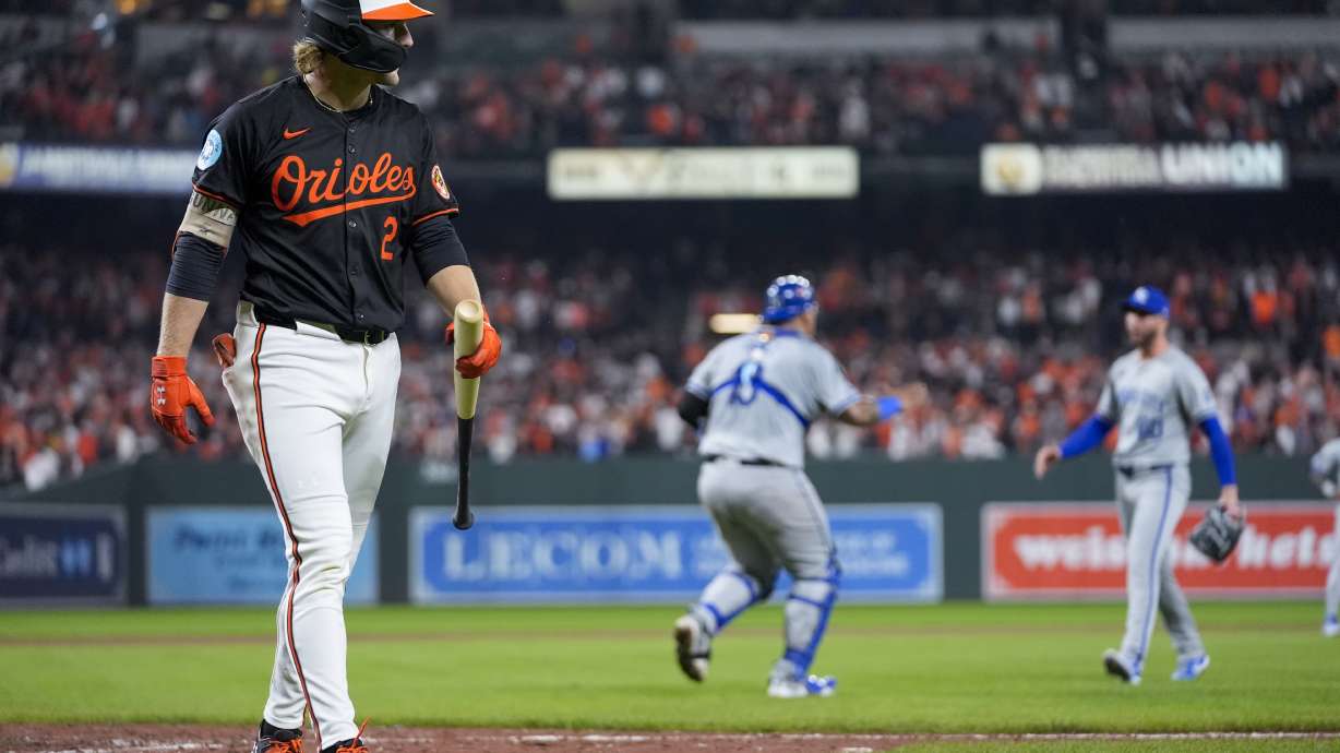 Baltimore Orioles' Gunnar Henderson, left, walks to the dugout after striking out for the final out as Kansas City Royals pitcher Lucas Erceg, right, and catcher Salvador Perez react following Game 2 of an AL Wild Card Series baseball game, Wednesday, Oct. 2, 2024 in Baltimore. The Royals won 2-1.