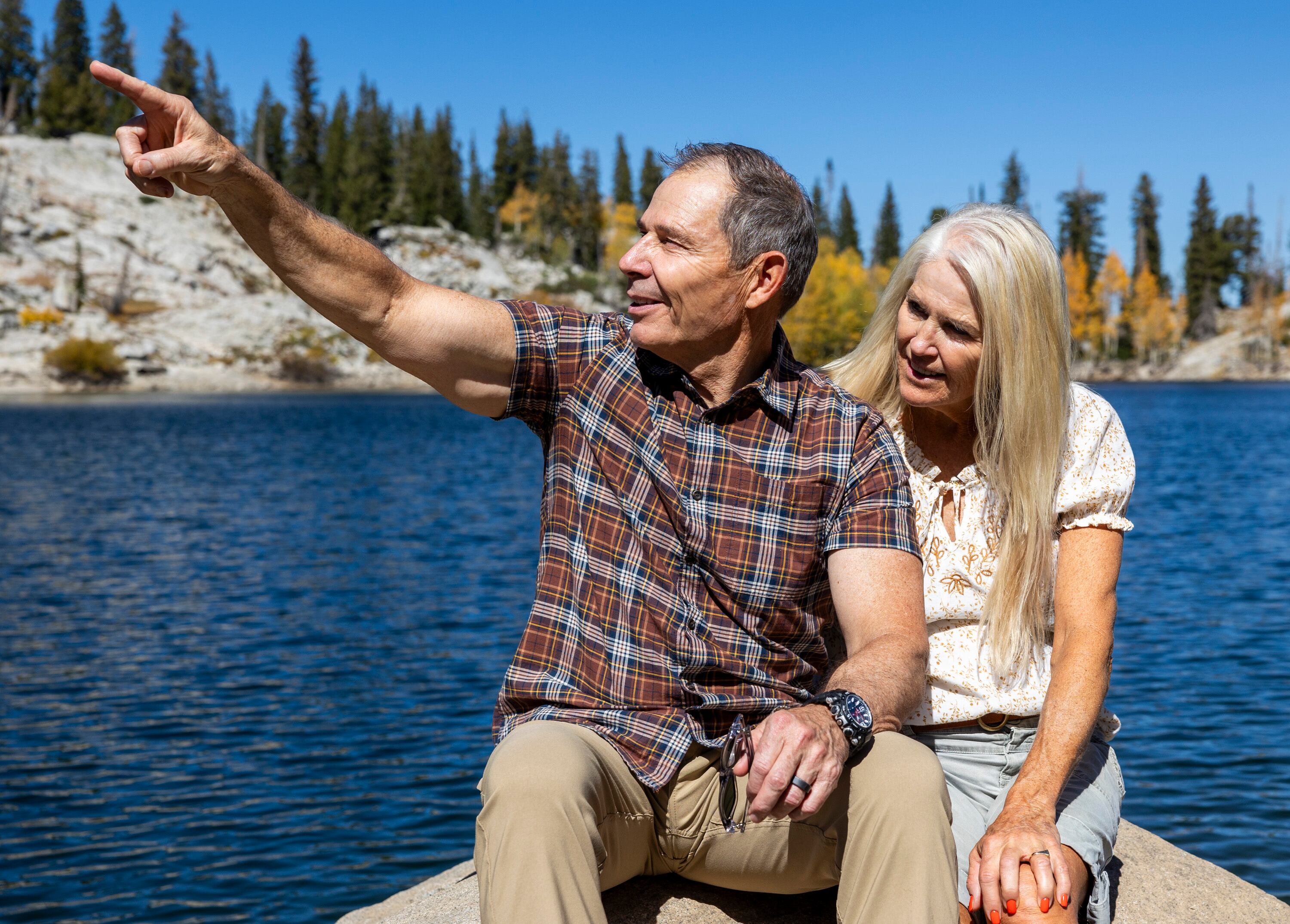 Rep. John Curtis, who is running for U.S. Senate, sits with his wife, Sue, on a rock and points to other trails he likes to hike in the area during a hike and interview with the Deseret News on Lake Mary Trail in Brighton on Sept. 28.