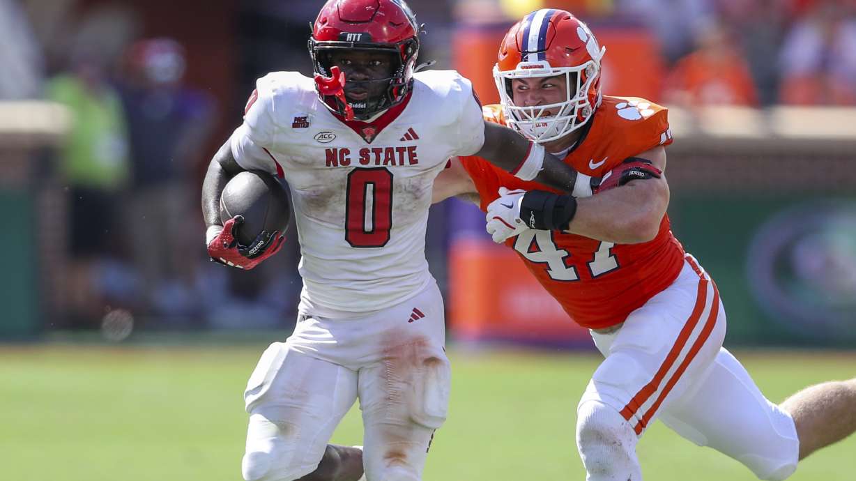 North Carolina State running back Kendrick Raphael (0) pulls away from Clemson linebacker Sammy Brown (47) during the second half of an NCAA college football game Saturday, Sept. 21, 2024, in Clemson, S.C.