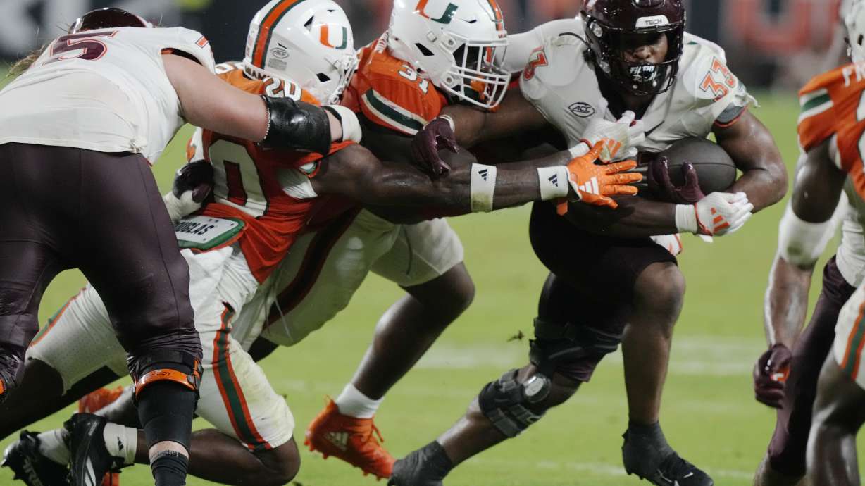 Miami linebacker Wesley Bissainthe (31) attempts to stop Virginia Tech running back Bhayshul Tuten (33) during the second half of an NCAA college football game, Friday, Sept. 27, 2024, in Miami Gardens, Fla.