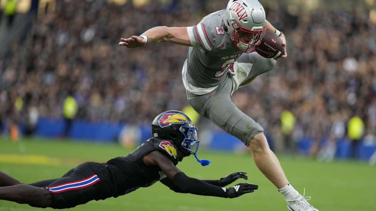 UNLV quarterback Matthew Sluka (3) leaps past Kansas cornerback Cobee Bryant (2) as he runs with the ball in the first half of an NCAA college football game Friday, Sept. 13, 2024, at Children's Mercy Park in Kansas City, Kan.