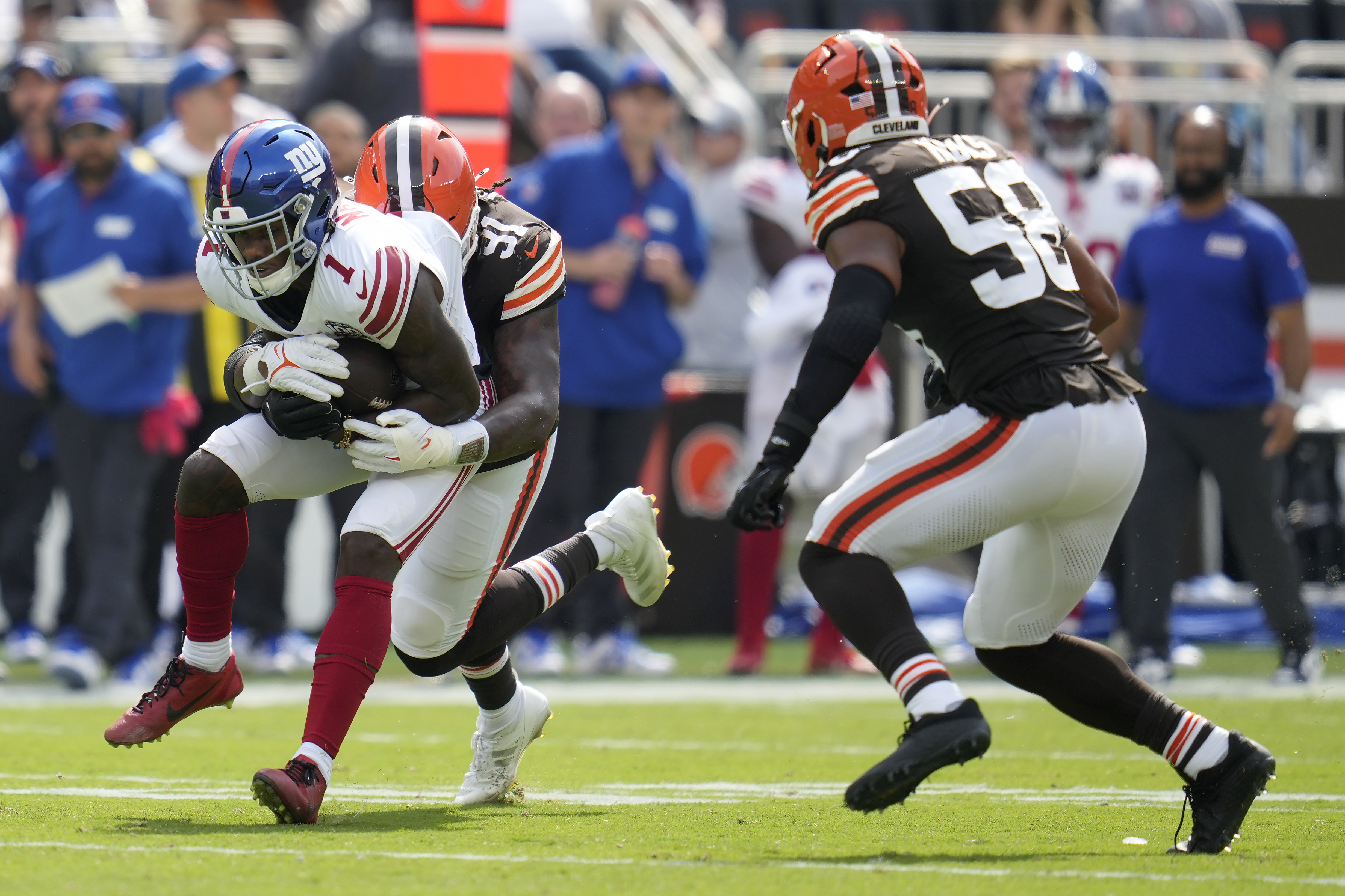 New York Giants wide receiver Malik Nabers, left, runs against Cleveland Browns defensive end Alex Wright, second from left, and linebacker Jordan Hicks (58) during the first half of an NFL football game, Sunday, Sept. 22, 2024 in Cleveland. 