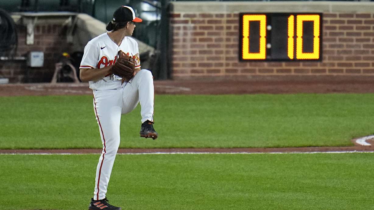 FILE - The pitch clock is visible as Baltimore Orioles starting pitcher Dean Kremer winds up to deliver during the sixth inning of a baseball game against the Boston Red Sox, April 24, 2023, in Baltimore, Md.